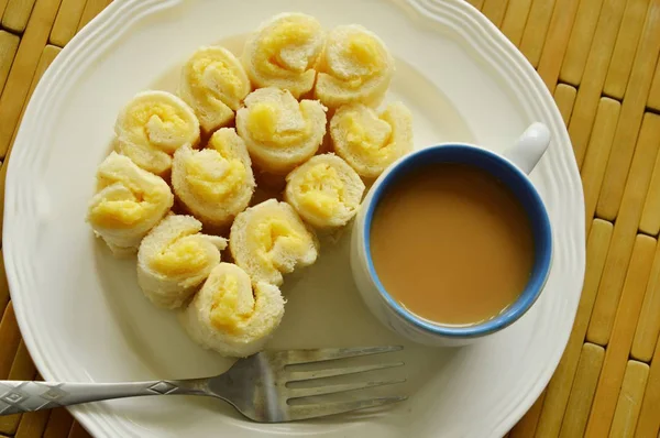 Pełne masło bułka jeść z kawy na talerzu — Zdjęcie stockowe