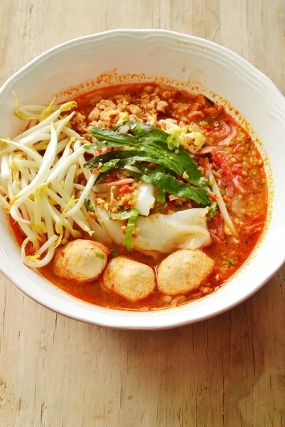 Fideos de arroz con bola de cerdo en sopa picante tom yum rematando brotes de frijol fresco en un tazón — Foto de Stock