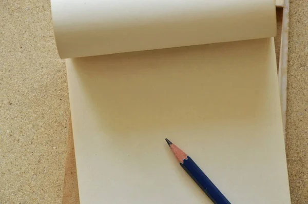 Μολύβι σε Λευκή Βίβλο σημειωματάριο στο γραφείο κόντρα πλακέ — Φωτογραφία Αρχείου