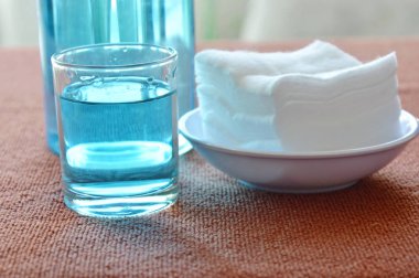 Mavi alkol için cam ve temiz beyaz pamuklu yara yıkama