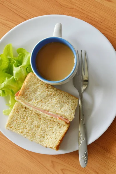 Bolonia de cerdo sándwich de trigo integral con roble verde fresco y café en el plato — Foto de Stock