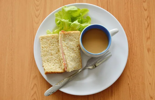 Schweinefleisch Bologna Vollkorn-Sandwich mit frischer grüner Eiche und Kaffee auf Teller — Stockfoto