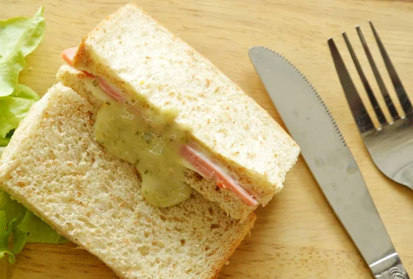 Bolonia de cerdo sándwich de trigo integral con tenedor y cuchillo en bloque de chuleta de madera — Foto de Stock