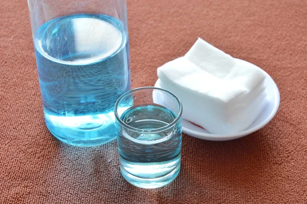 Mavi alkol için cam ve temiz beyaz pamuklu yara yıkama