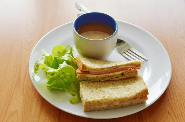 Varkensvlees bologna volkoren sandwich met verse groene eiken en koffie op plaat — Stockfoto