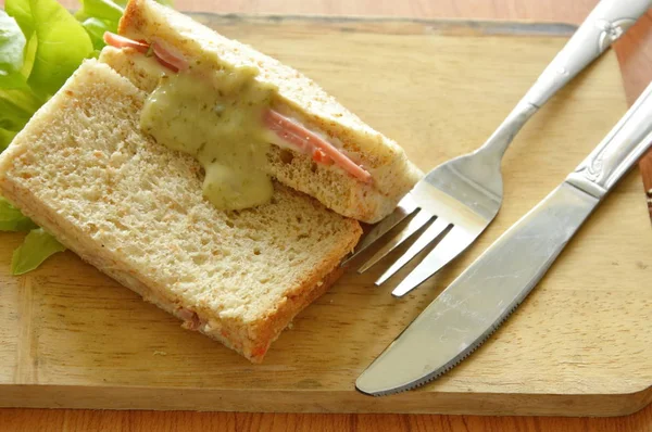 Bolonia de cerdo sándwich de trigo integral con tenedor y cuchillo en bloque de chuleta de madera — Foto de Stock