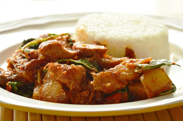 Aduk pedas goreng kari babi panggang dengan ramuan makan pasangan dengan nasi di piring — Stok Foto