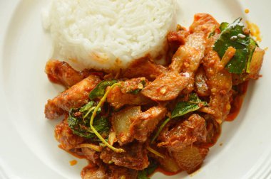 Baharatlı kızarmış domuz eti ve sebzeli köri. Tabakta pirinçli çift.