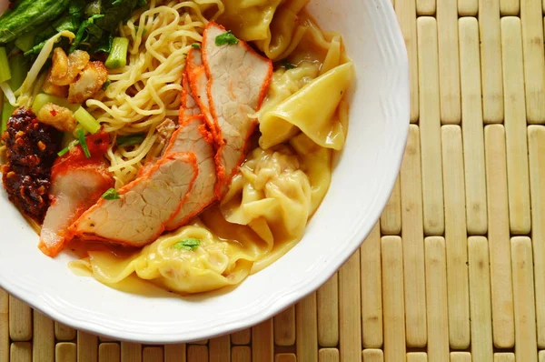 Macarrão amarelo chinês cobertura fatia churrasco porco e bolinho em sopa — Fotografia de Stock