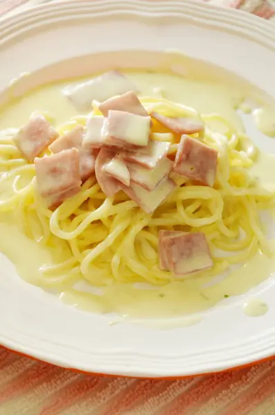 Λευκή σάλτσα μακαρονιών Κορυφολόγημα φέτα χοιρινό ζαμπόν στο πιάτο — Φωτογραφία Αρχείου