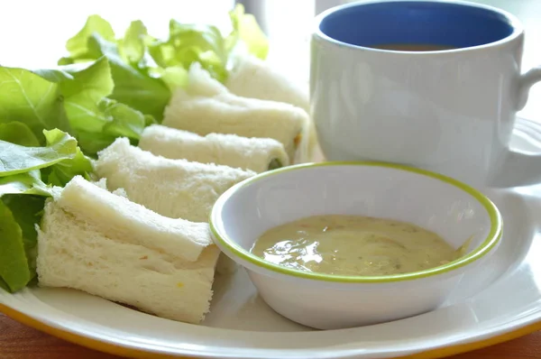Rollo de pan relleno de bolonia y roble verde con taza de café en el plato — Foto de Stock
