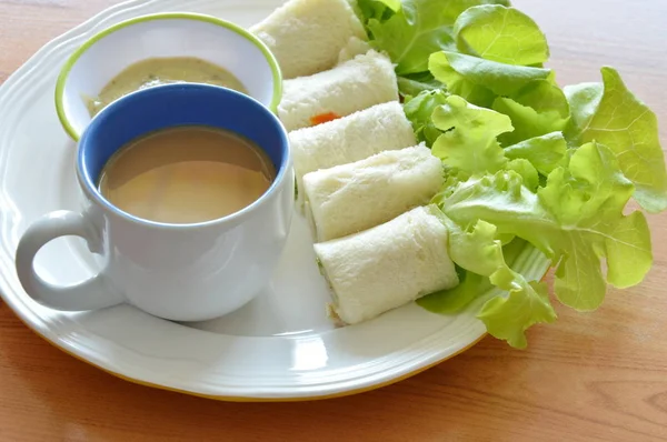 Rolo de pão recheado bolonha e carvalho verde com xícara de café no prato — Fotografia de Stock