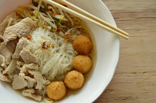 Rijst vermicelli topping garnalen bal en plakje gekookt varkensvlees in soep eten door houten chopstick — Stockfoto