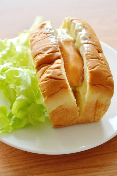 Хліб, наповнений свинячою ковбасою, майонез з зеленим дубом на блюді — стокове фото