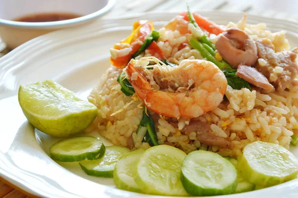 Жареный рис с креветками и свининой на тарелке — стоковое фото