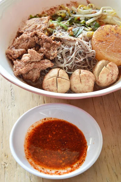 Rice vermicelli topping pork ball and meat in brown soup with chili sauce — Stock Photo, Image