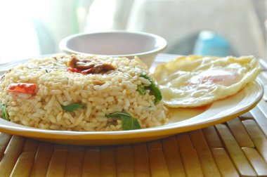 Baharatlı kızarmış pilav domuz eti ve fesleğen yaprak biber balık soslu kızarmış yumurta tepesi