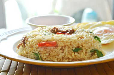 Baharatlı kızarmış pilav domuz eti ve fesleğen yaprak biber balık soslu kızarmış yumurta tepesi