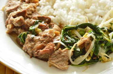 haşlanmış domuz eti ve fasulye filizli güveç pilavla birlikte yenir.