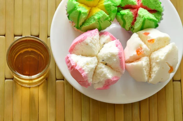 Berbagai macam cupcake katun berwarna-warni di atas piring dan cangkir teh — Stok Foto