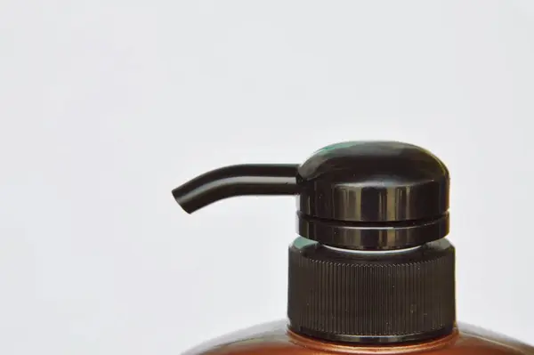 Preto shampoo garrafa bomba cabeça imprensa no fundo branco — Fotografia de Stock