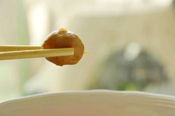 Fläsk bollen plockning i vit plast chopstick — Stockfoto