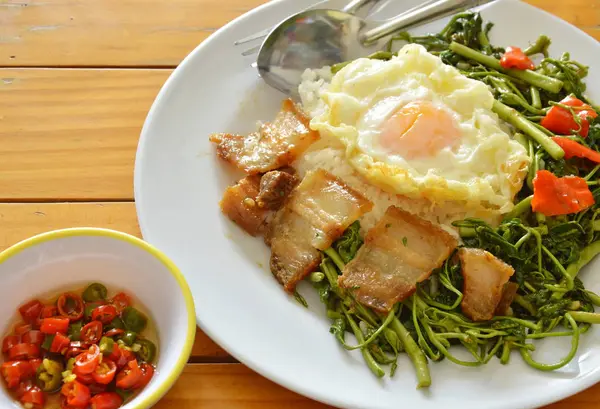 Aduk mimosa air goreng dengan daging babi renyah topping telur di atas nasi — Stok Foto