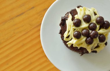 Çikolatalı kek vanilyalı krema ve top plaka üzerinde tepesi