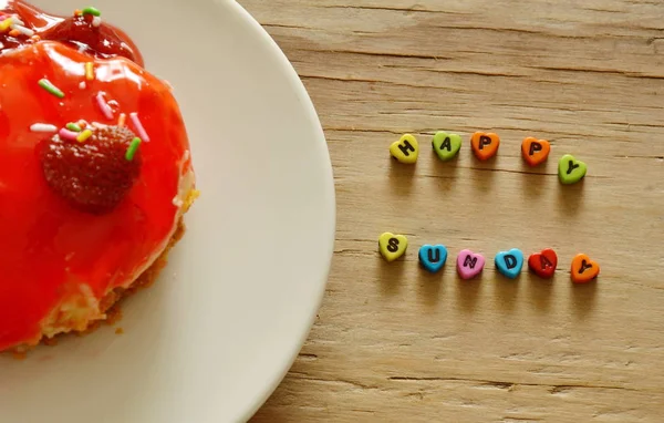 Carta arreglada feliz domingo palabra y pastel de fresa en el plato — Foto de Stock