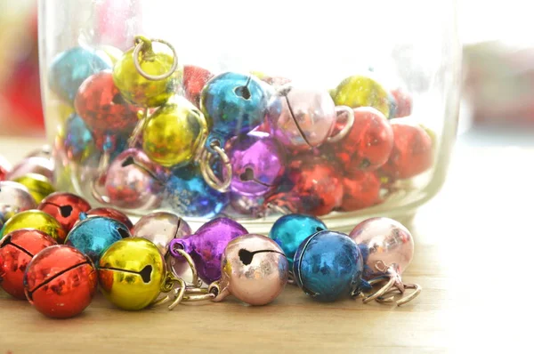 Colorful bells rolling on wooden board — Stock Photo, Image