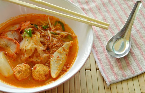 Fideos finos de arroz rematando rebanada de cerdo a la parrilla y bola de pescado en sopa picante —  Fotos de Stock