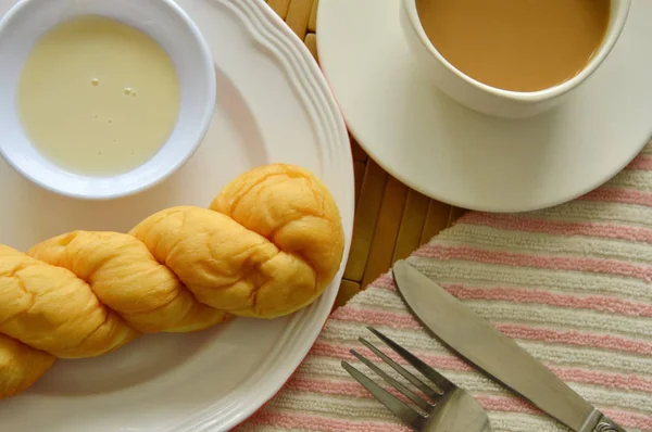 Torcer o pão mergulhando com leite condensado adoçado e xícara de café — Fotografia de Stock