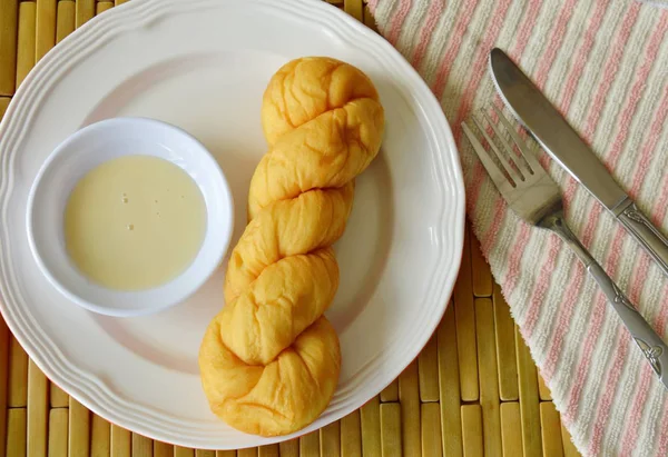 ขนมปังบิดจุ่มด้วยนมข้นหวานบนจาน — ภาพถ่ายสต็อก