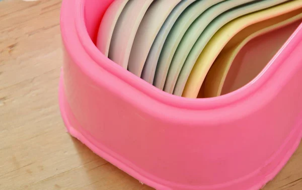 五颜六色的塑料汤勺子和筷子在粉红色的盒子 — 图库照片