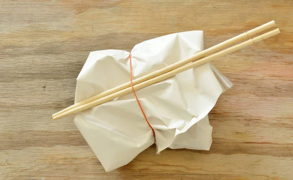 Siap makan dalam kemasan kertas oleh karet gelang dan sumpit kayu — Stok Foto