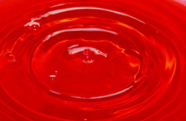 Woda spada i splash w czerwonym tle — Zdjęcie stockowe