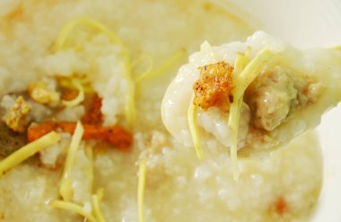  kıyılmış domuz eti ve dilim zencefil üzerinde plastik çorba kaşığı haşlanmış pirinç