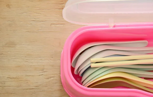 Cuchara de sopa de plástico colorido y palillos en caja rosa — Foto de Stock