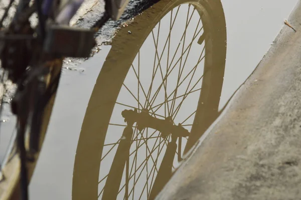 Riflesso della ruota della bicicletta in inondazione d'acqua sulla strada dopo la pioggia — Foto Stock