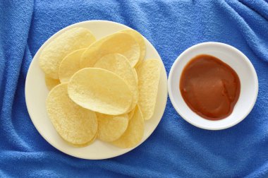  Ketçap ile tabak daldırma üzerinde gevrek ve tuz patates cipsi