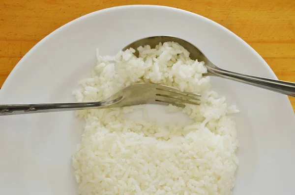 Łyżka i widelec scoop zwykły ryż z płytki do jedzenia — Zdjęcie stockowe