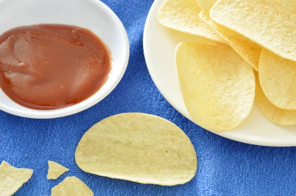 Batatas fritas crocantes e salgadas no prato mergulhando com ketchup — Fotografia de Stock