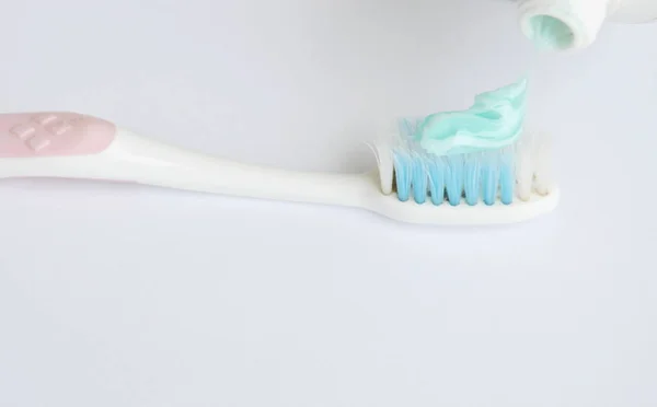 Toothpaste squeezing on toothbrush in white background — Stock Photo, Image