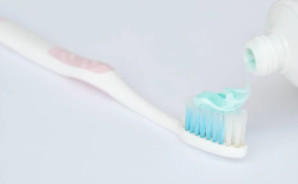 Spremere il dentifricio mettere lo spazzolino su sfondo bianco — Foto Stock