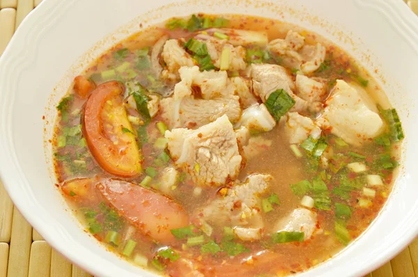 Hueso de cerdo caliente y picante con tamarindo y sopa de hierbas tailandesas en un tazón — Foto de Stock