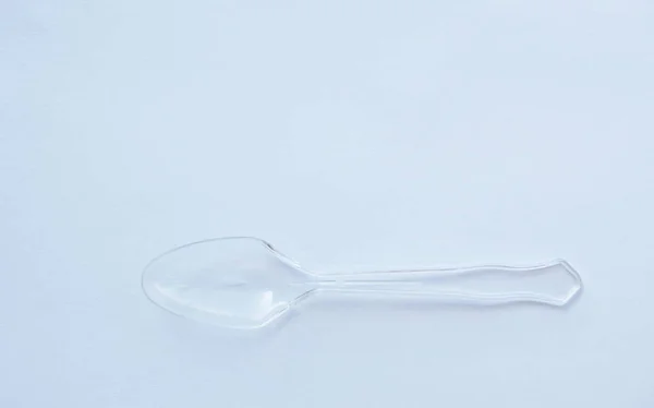 Colher de plástico transparente e translúcido no fundo branco — Fotografia de Stock