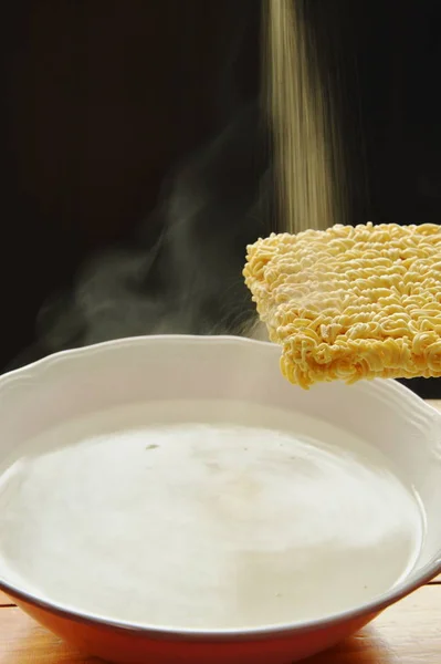 Instant noodles floating on hot water in bowl and dressing seasoning powder — Stock Photo, Image