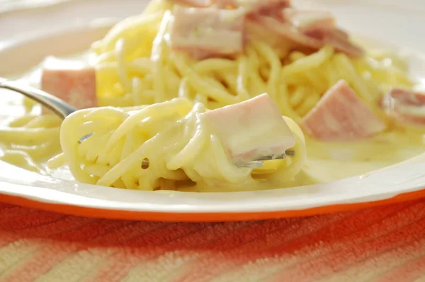 Spaghetti white cream sauce topping slice ham pork rolled on fork — Stock Photo, Image