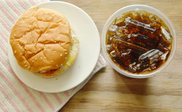 Hamburger z kurczaka i cola z lodem w plastikowy kubek — Zdjęcie stockowe
