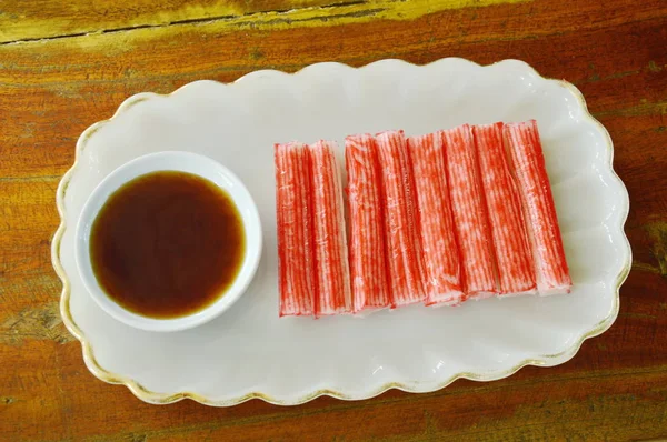 Palo de cangrejo de imitación hecho de pescado con salsa de soja en el plato — Foto de Stock